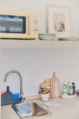 a kitchen counter with a sink and a microwave at Studio Palazzo, Antique Charm with Romantic Balcony and AC in Porto