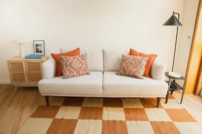 a living room with a couch with pillows on it at Apartment 1 min walk from Metro and Trendiest Neighborhood Bonfim in Porto