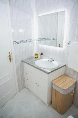 a white bathroom with a sink and a mirror at Apartment 1 min walk from Metro and Trendiest Neighborhood Bonfim in Porto