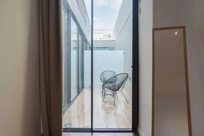 a chair sitting on a balcony looking out a window at Liiiving in Porto - The Prestige Apartment C in Porto