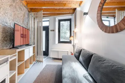 a living room with a couch and a mirror at GuestReady - charming retreat in Porto in Porto