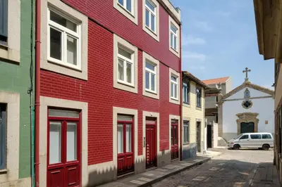 a red building with red doors on a street at Magnolia 3 Luxury with AC Metro Downtown Porto in Porto
