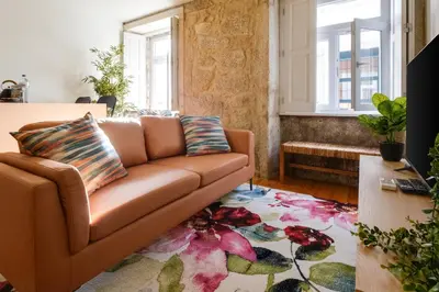 a living room with a brown couch and a rug at Magnolia 3 Luxury with AC Metro Downtown Porto in Porto