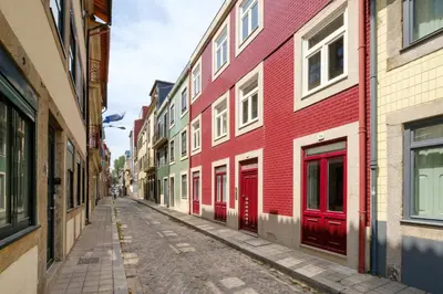 an empty street with red doors in an alley at Magnolia 3 Luxury with AC Metro Downtown Porto in Porto