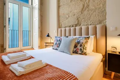 a bedroom with a white bed with a large window at Luxury Style 8 with AC Downtown Porto near Metro in Porto