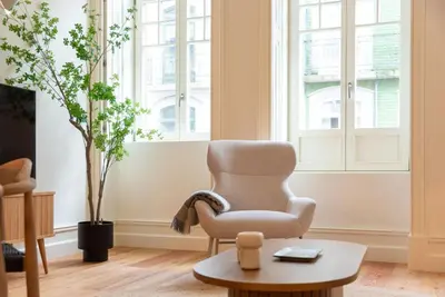 a living room with a chair and a table at Almada 559 - Eça Atelier by Lisbeyond in Porto