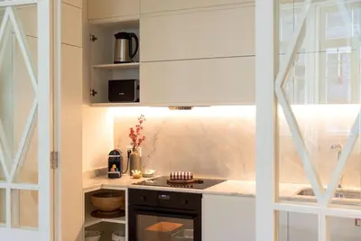 a kitchen with white cabinets and a stove top oven at Almada 559 - Eça Atelier by Lisbeyond in Porto