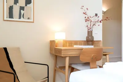 a small table in a room with a chair and a lamp at Almada 559 - Eça Atelier by Lisbeyond in Porto