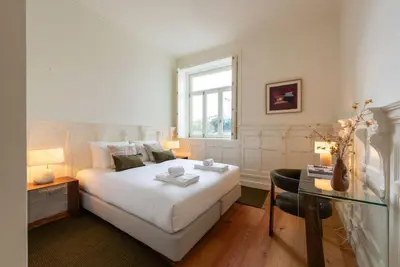 a bedroom with a white bed and a window at Almada 559 - Ortigão Residence by Lisbeyond in Porto