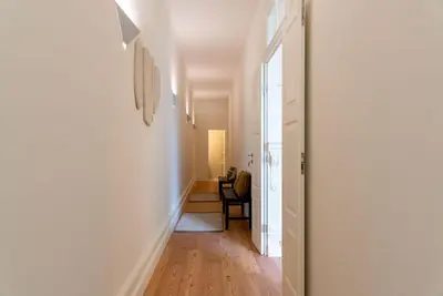 a hallway leading to a living room with a table at Almada 559 - Ortigão Residence by Lisbeyond in Porto