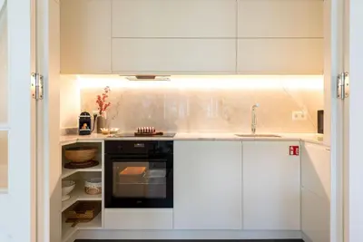 a kitchen with white cabinets and a black oven at Almada 559 - Ortigão Residence by Lisbeyond in Porto