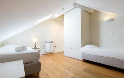 a white room with two beds and a table at Best Guest Porto Hostel in Porto