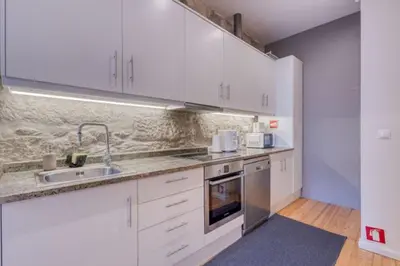 a kitchen with white cabinets and a sink at OPORTO GUEST Alegria126 in Porto