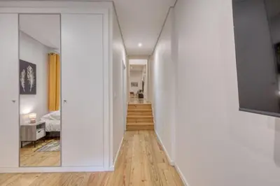 a hallway leading to a bedroom with a mirror at OPORTO GUEST Alegria126 in Porto