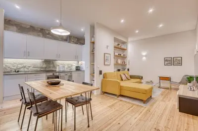 a kitchen and living room with a table and a yellow couch at OPORTO GUEST Alegria126 in Porto