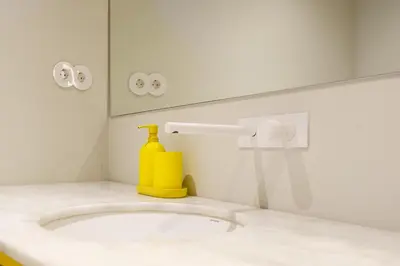 a shower with a light on a yellow wall at The Riverside House in Porto
