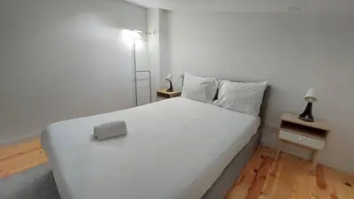 a white bedroom with a white bed and a desk at Gaia Apartments by the Wine Cellars in Vila Nova de Gaia
