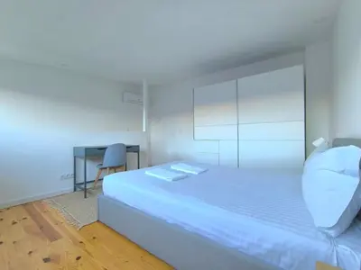 a small bedroom with a bed and a table at Gaia Apartments by the Wine Cellars in Vila Nova de Gaia