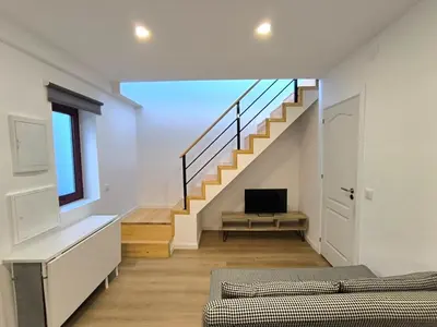 a living room with a staircase and a television at Gaia Apartments by the Wine Cellars in Vila Nova de Gaia