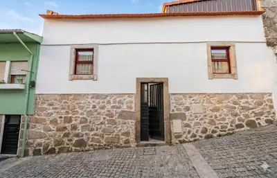 an empty hallway between two brick buildings with a red door at Gaia Apartments by the Wine Cellars in Vila Nova de Gaia