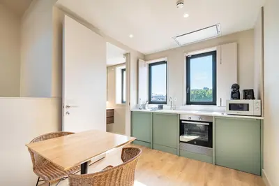 a kitchen with a wooden table and some windows at Bonjardim Suites in Porto