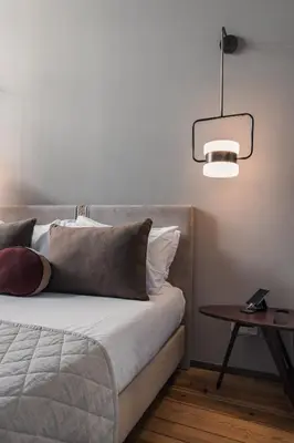 a bedroom with a bed with a lamp and a table at Condes de Azevedo Palace Apartments in Porto