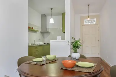 a kitchen with a wooden table with bowls on it at Almond Biscuit Porto Historic Center in Porto