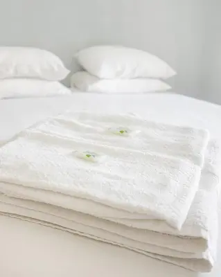 a stack of white towels on a bed at Almond Biscuit Porto Historic Center in Porto