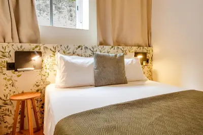 a bedroom with a bed with white sheets and pillows at Porto Covelo Park Apartment in Porto