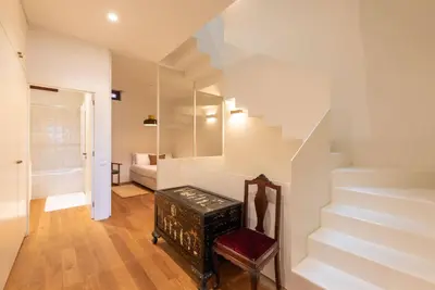 a room with stairs and a chair and a stool at Riverfront Heritage House in Vila Nova de Gaia