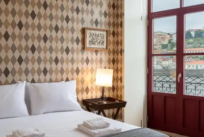 a bedroom with a bed with a lamp and a window at Riverfront Heritage House in Vila Nova de Gaia