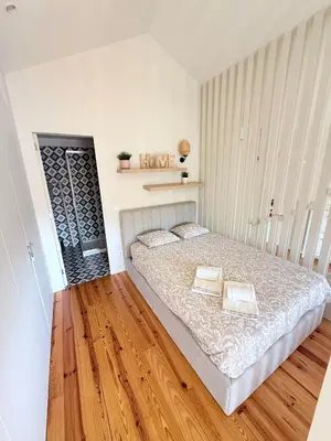 a bedroom with a large bed and a wooden floor at Bonjardim Bright Studio in Porto