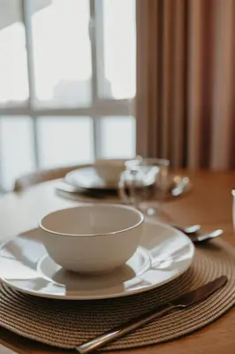 a white bowl on a plate on a table at Bolhão Downtown in Porto