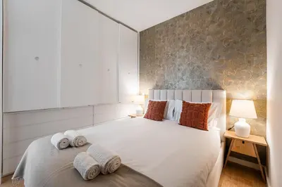 a bedroom with a white bed with towels on it at GuestReady - Crown Garden Escape in Porto