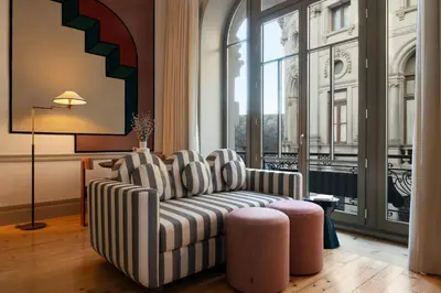 a living room with a couch and a chair and a window at Aliados 9 - Luxury in the Heart of Porto in Porto