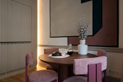 a dining room table with chairs and a vase of flowers at Aliados 9 - Luxury in the Heart of Porto in Porto