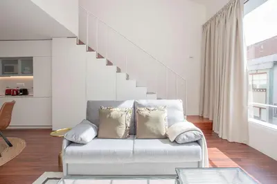 a living room with a couch and a staircase at Liiiving in Porto - Luxury Gallery Apartment I in Porto