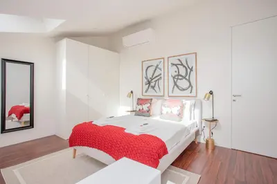 a white bedroom with a bed with a red blanket at Liiiving in Porto - Luxury Gallery Apartment I in Porto
