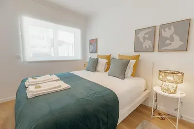 a bedroom with a large bed with a green blanket at Cozy Bonfim by Hosty in Porto