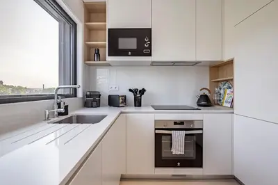 a white kitchen with a sink and a microwave at Nomad's Lux - 2bdr & Parking Flores Square Porto in Porto