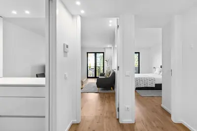 a white bedroom with a bed and a large window at Bright Apartment with Balcony & Parking | Bonfim in Porto