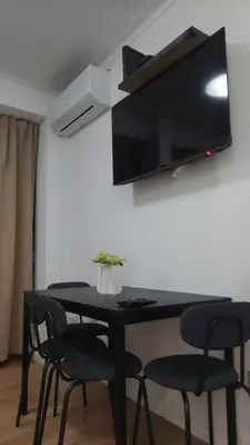 a black table with chairs and a tv on a wall at Elegance in Porto in Porto