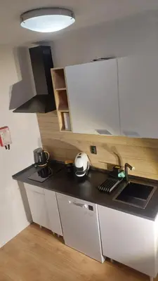 a kitchen with white cabinets and a black counter top at Elegance in Porto in Porto