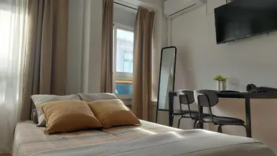 a bedroom with a bed and a table and a window at Elegance in Porto in Porto