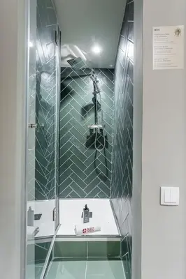 a bathroom with a shower with green tiles at GuestReady - The Cats Studios in Porto