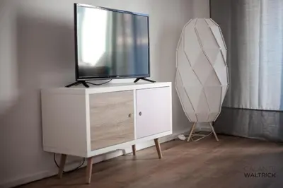 a tv on top of a dresser in a room at Quiet 3BR Flat - City Center - Warm and Bright - Remote Work in Porto