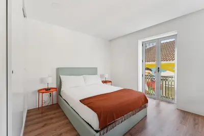 a white bedroom with a bed and a window at GuestReady - enjoy the Best of Porto in Porto