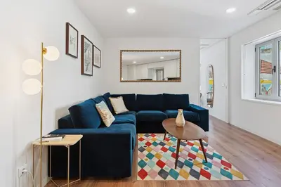 a living room with a blue couch and a mirror at GuestReady - enjoy the Best of Porto in Porto