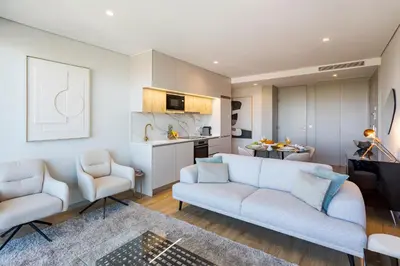 a living room with a couch and two chairs and a kitchen at Modern Porto Retreat by HostWise in Vila Nova de Gaia