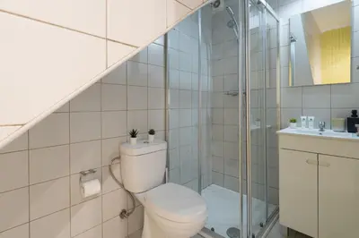 a bathroom with a toilet and a glass shower at Authentic Porto Home by HostWise in Porto